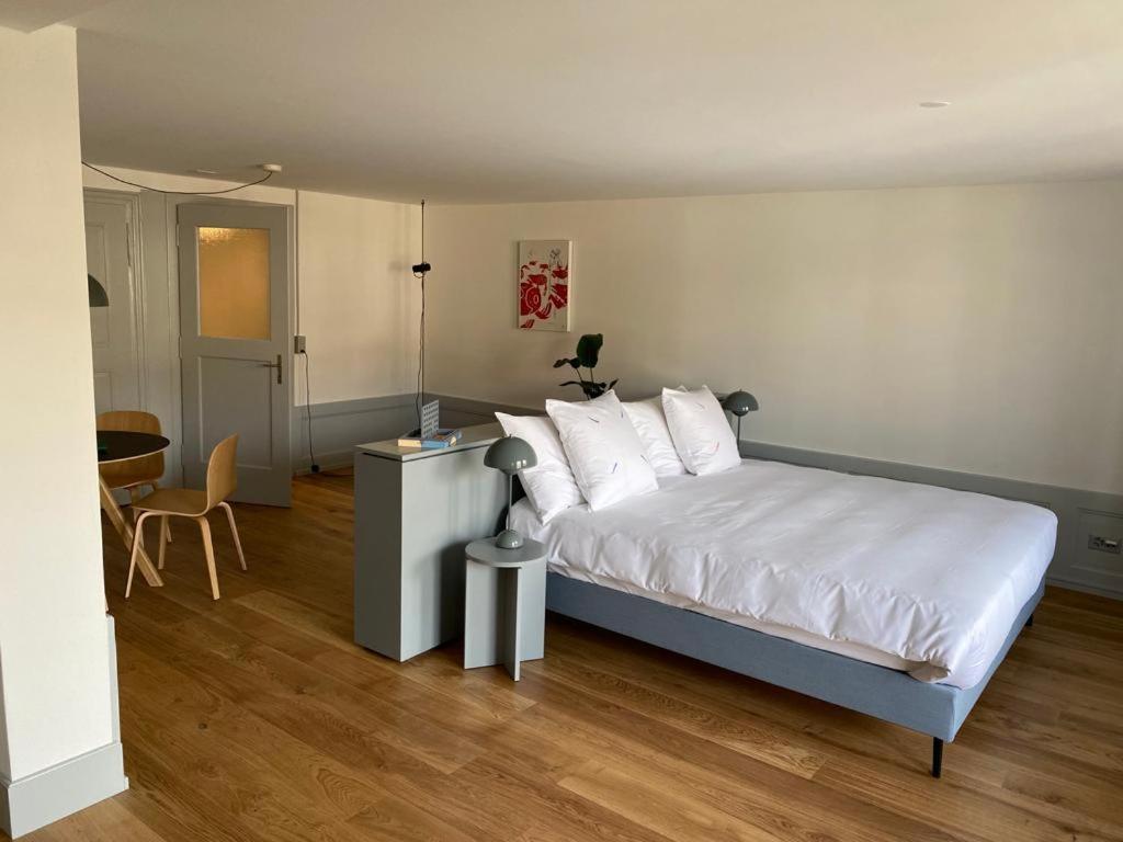 a bedroom with a bed with white sheets and white pillows at La Sauvage in Fribourg