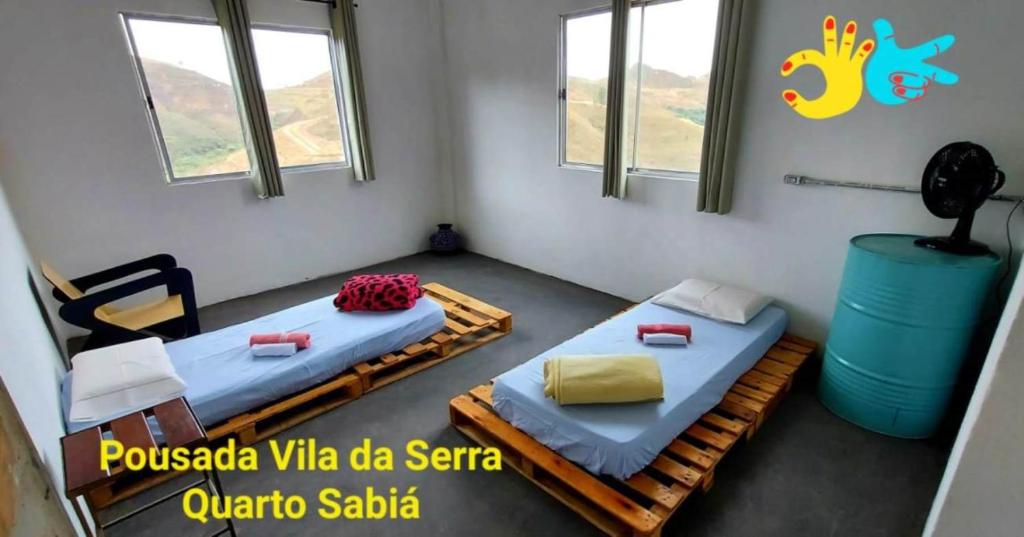 dwa łóżka w pokoju z dwoma oknami w obiekcie Pousada Vila da Serra - Quarto Sabiá w mieście Nova Lima