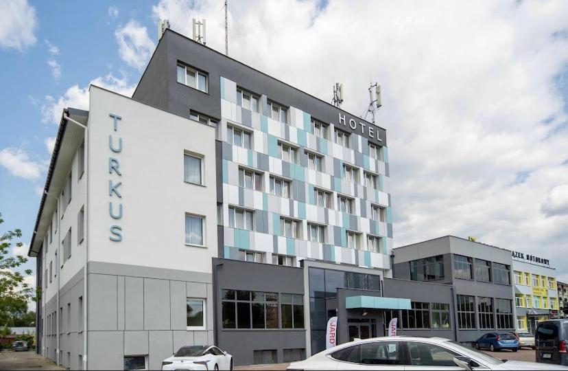 un hôtel avec une voiture garée devant lui dans l'établissement Hotel Turkus, à Białystok