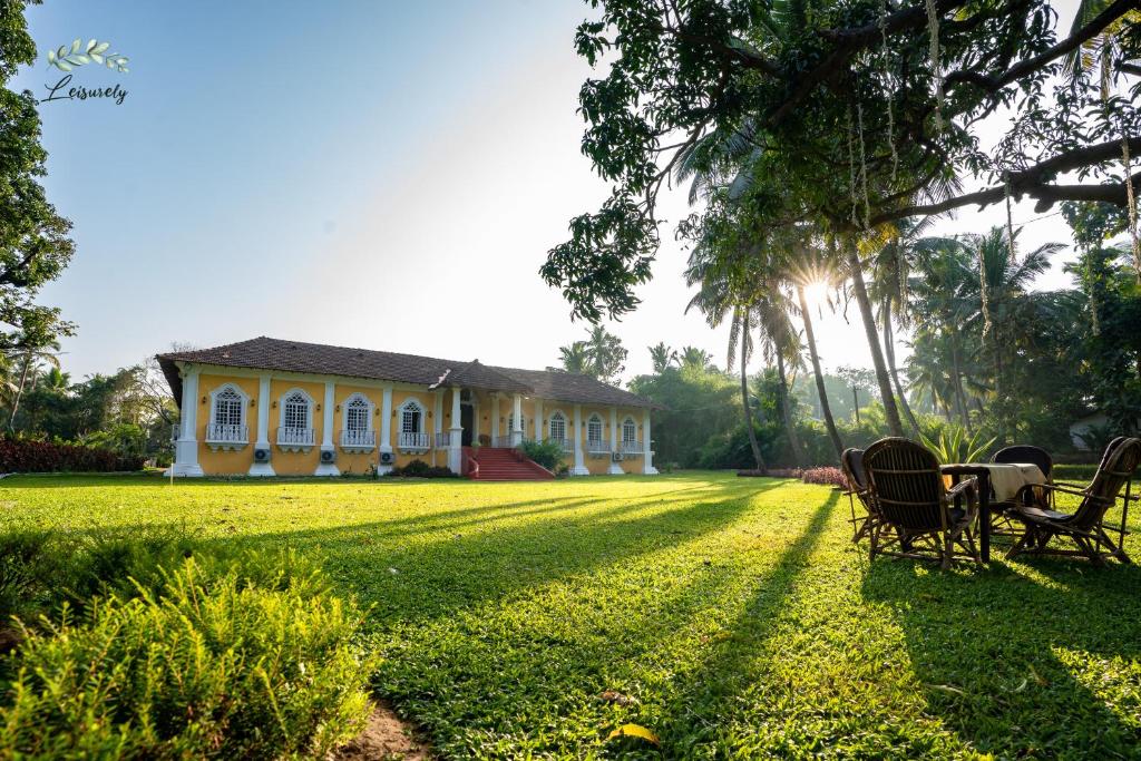 ベノーリムにあるSilva Heritage Resort Goaの芝生の上に椅子とテーブルを置いた家