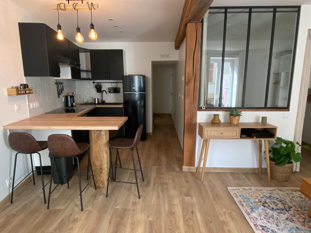 a kitchen with a wooden table and chairs in a room at Grand T1 Allevard centre in Allevard