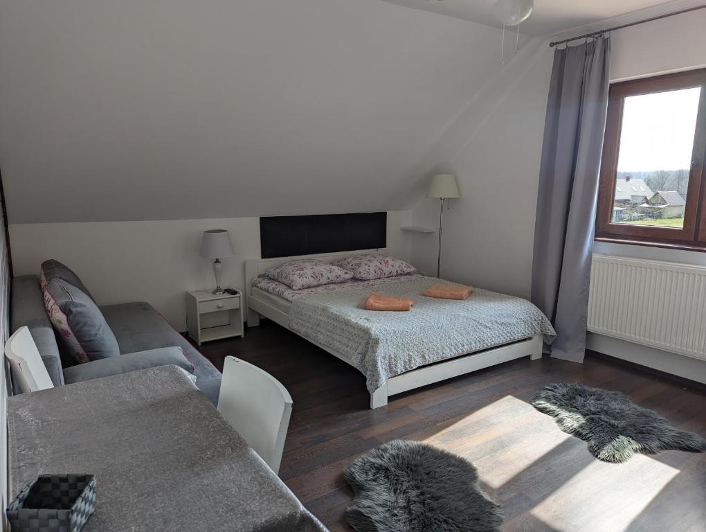 um quarto com uma cama e uma sala de estar em Sosnowa Polana Białowieża em Białowieża