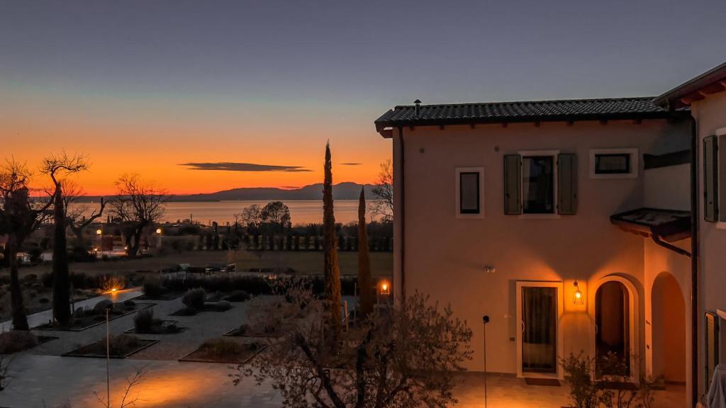 a building with a sunset in the background at Natiia Relais - Adults Only in Lazise