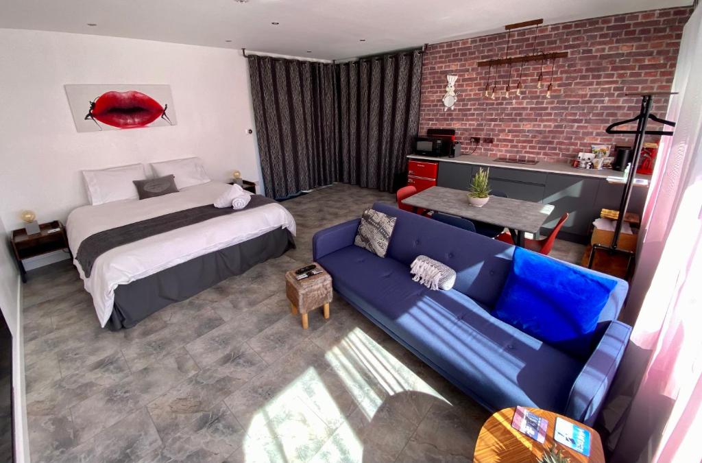 Saint DavidsにあるDalgety Bay Luxury Studio Apartmentのベッドルーム(ベッド1台、青いソファ付)