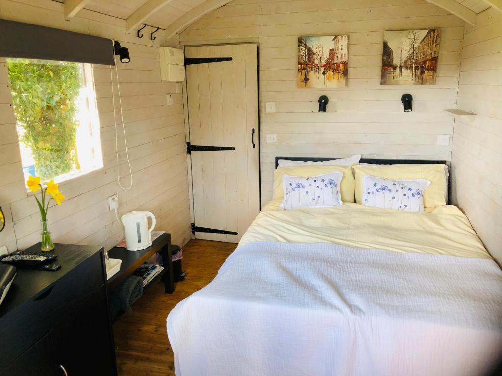 a bedroom with a large bed in a small room at The Cherry Tree Gypsy Wagon in Banbury