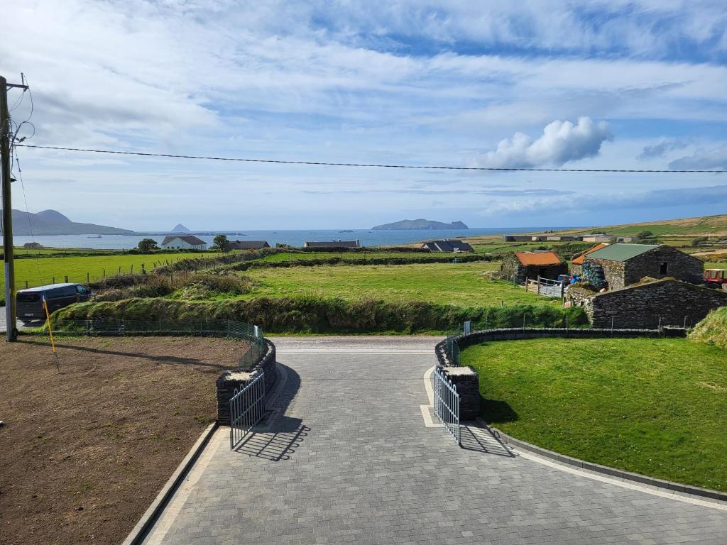 una strada che conduce in un campo con vista sull'oceano di Dunquin House Bed and Breakfast a Dunquin