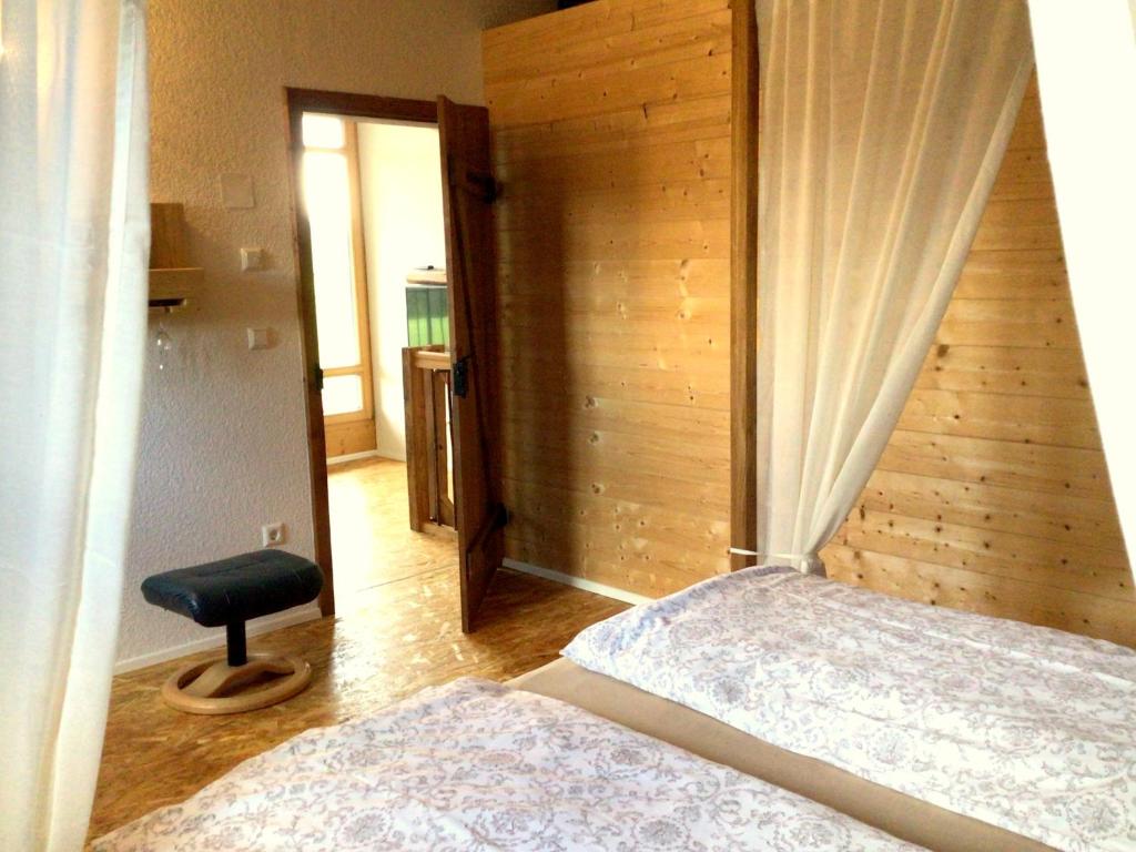 a bedroom with a bed and a wooden wall at Holstein-Höfle, Rindalphorn in Argenbühl