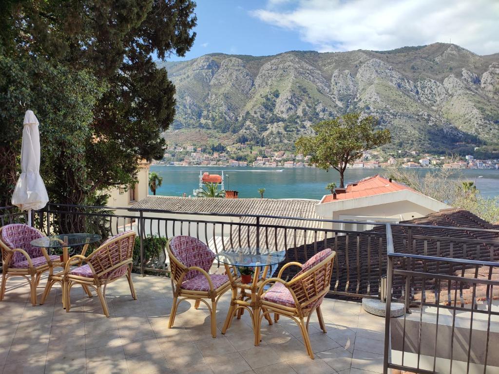 eine Terrasse mit einem Tisch und Stühlen sowie Blick auf das Wasser in der Unterkunft Bay Mola Aparts in Kotor