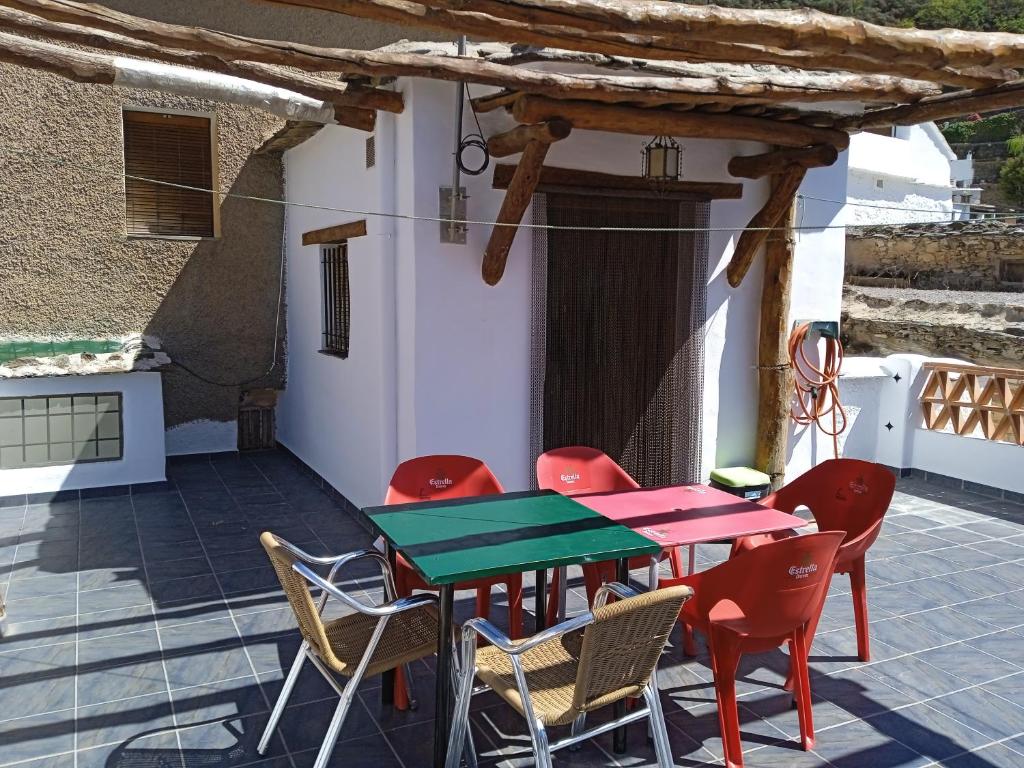 a patio with a table and chairs on a house at Casa Los Trillizos in Pampaneira