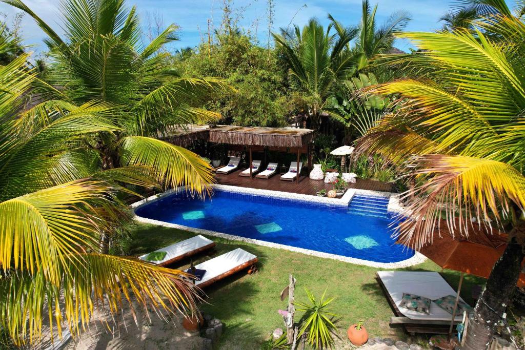 una vista aérea de una piscina con palmeras en Bambusada Boutique Hotel, en Canavieiras