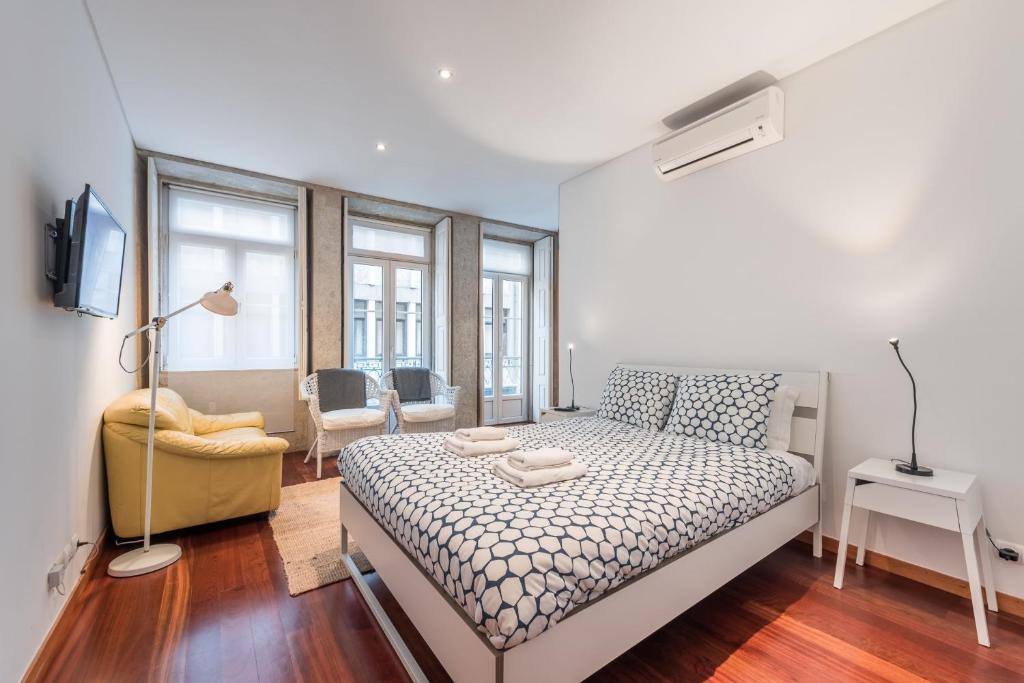 een slaapkamer met een bed, een bank en ramen bij GuestReady - City central suite in Porto in Porto