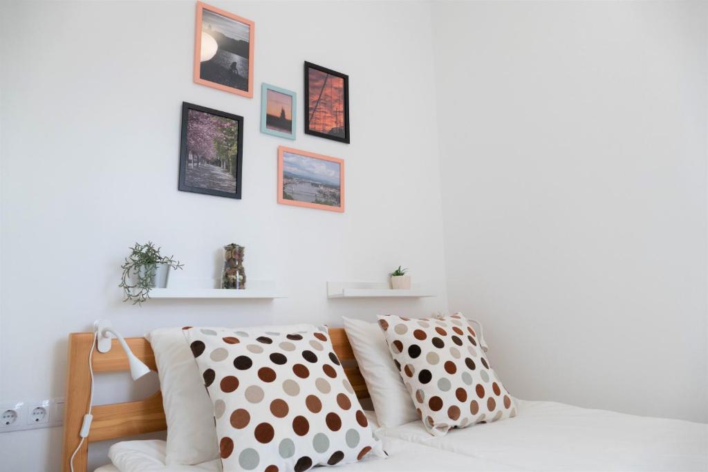 um quarto branco com almofadas de bolinhas num sofá em Citymajor Apartment-Free parking em Budapeste