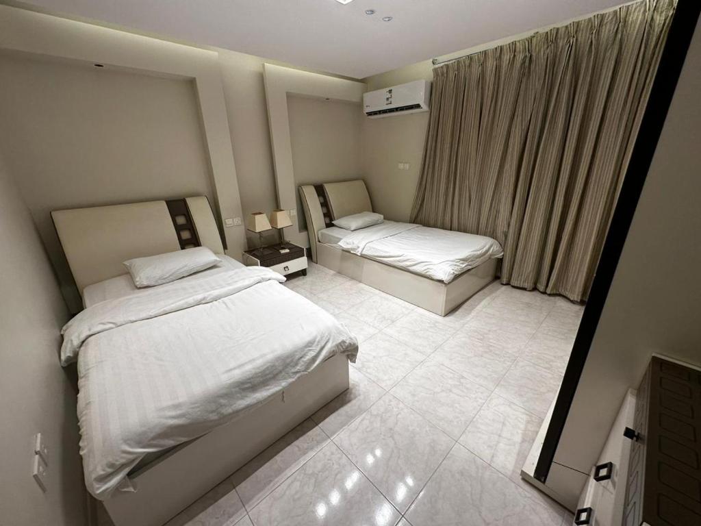 a hotel room with two beds and a mirror at Lovely High Quality Self Check-in Apartments شقق سلام بالدخول الذاتي in Medina