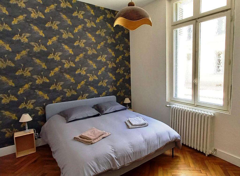 una camera con un letto con una parete decorata con fiori di Histoire de Loire : GABRIELLE a Saumur