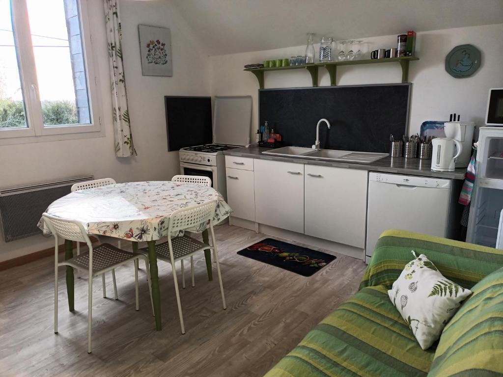 een woonkamer met een tafel en een keuken bij ecrin de fleurs et verdure in Sept-vents