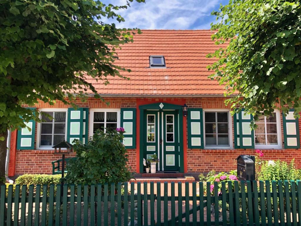 ein rotes Backsteinhaus mit orangefarbenem Dach in der Unterkunft Ferienwohnung Leitzsch in Wustrow