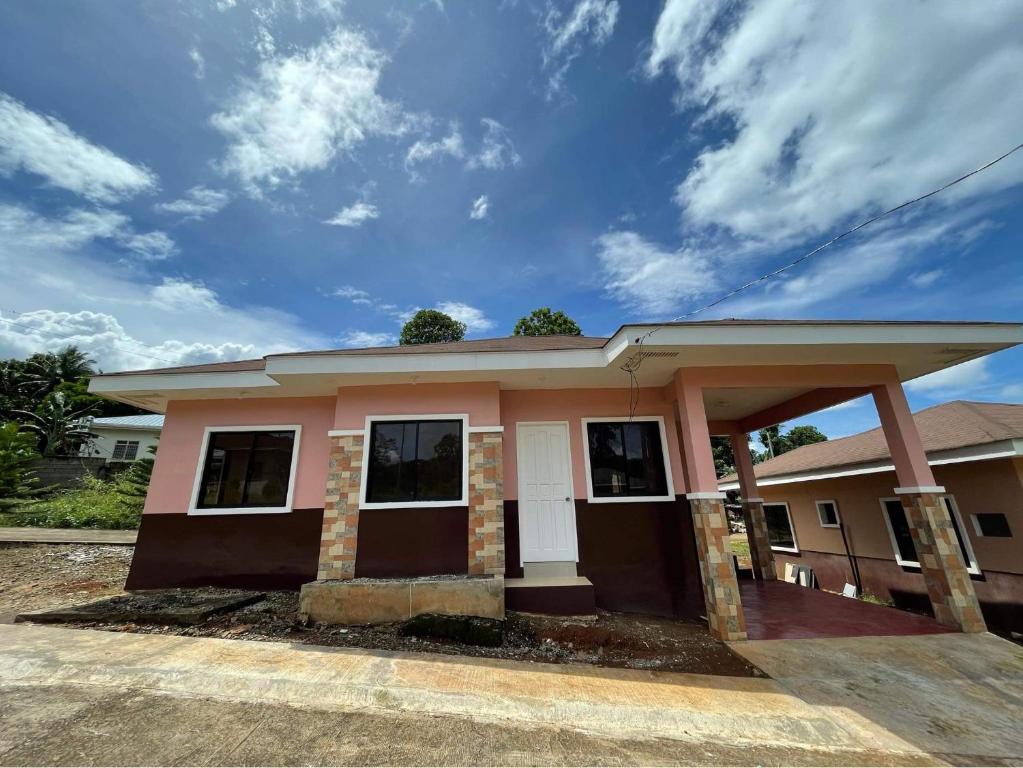 a small pink house with a sky at Clementine’s Subdivision House in Oroquieta