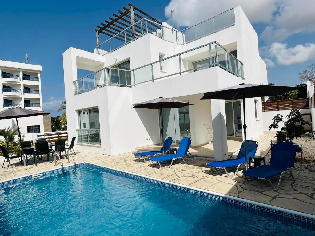 a villa with a swimming pool in front of a house at Villa Mulberry Retreat 0,5Km From Everything in Coral Bay