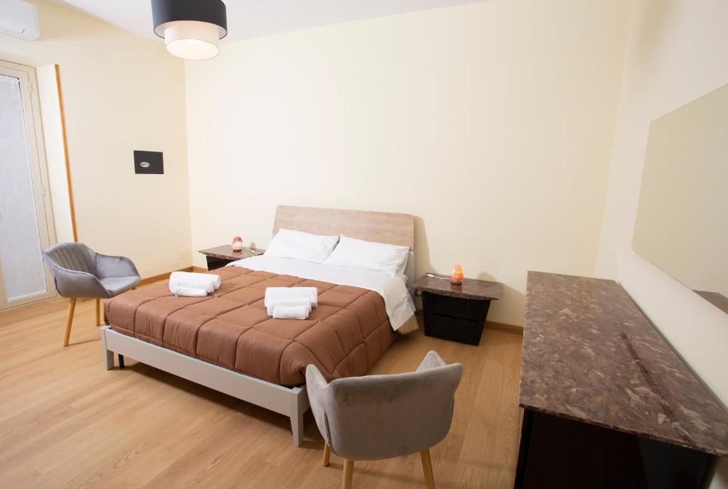 een slaapkamer met een bed en een tafel en stoelen bij CASA CANNEZIO in Ragusa