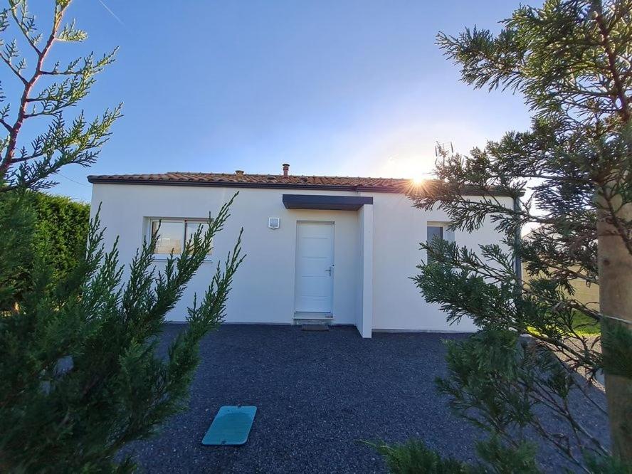 une maison blanche avec une porte blanche et des arbres dans l'établissement MAISON RECENTE 58 ABBAYE, à Saint-Jean-de-Monts