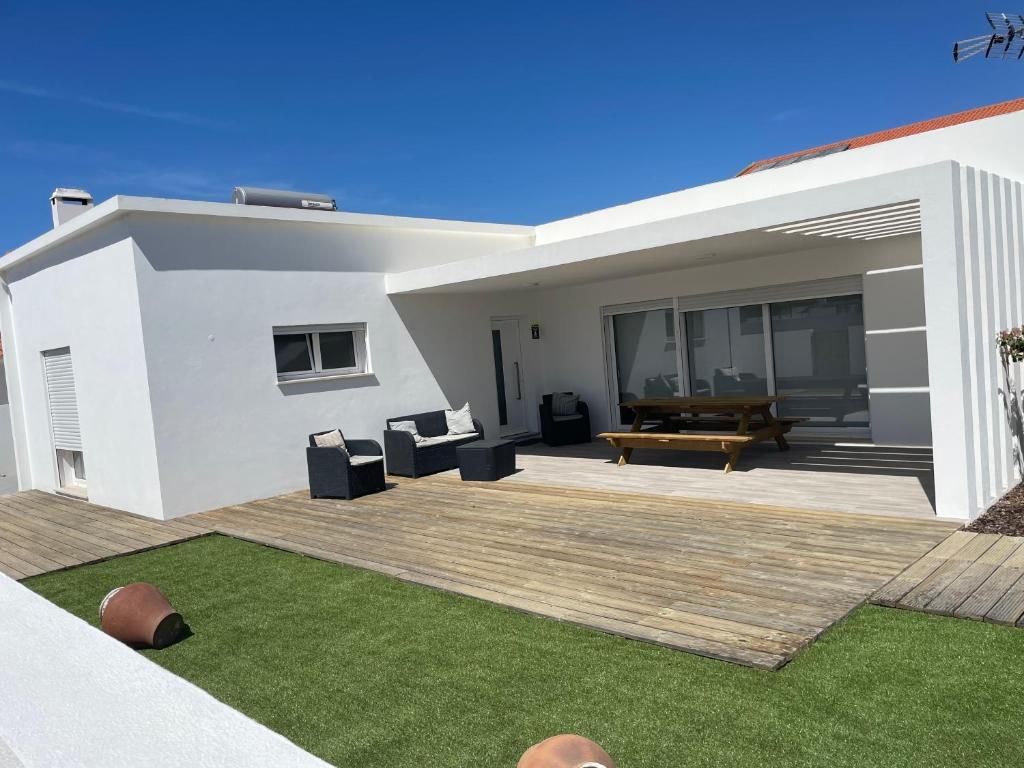 un patio trasero de una casa blanca con terraza de madera en Casa Sofia, en Carvalhal