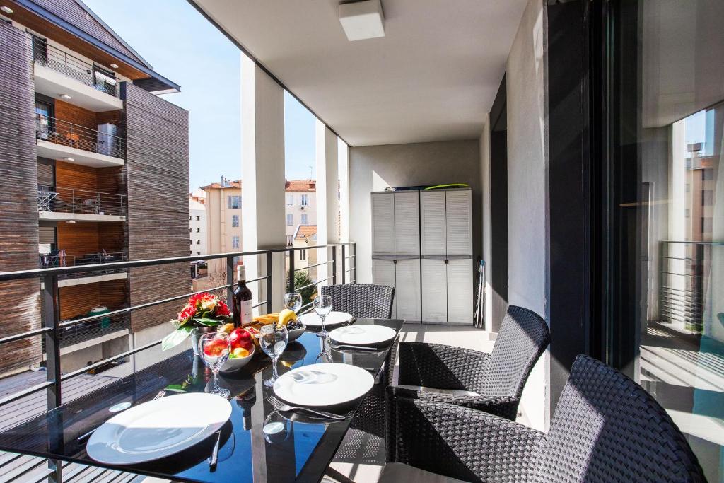 un balcon avec une table et des chaises sur un balcon dans l'établissement VICTOR HUGO AP4159 Nice, by Riviera Holiday Homes, à Nice