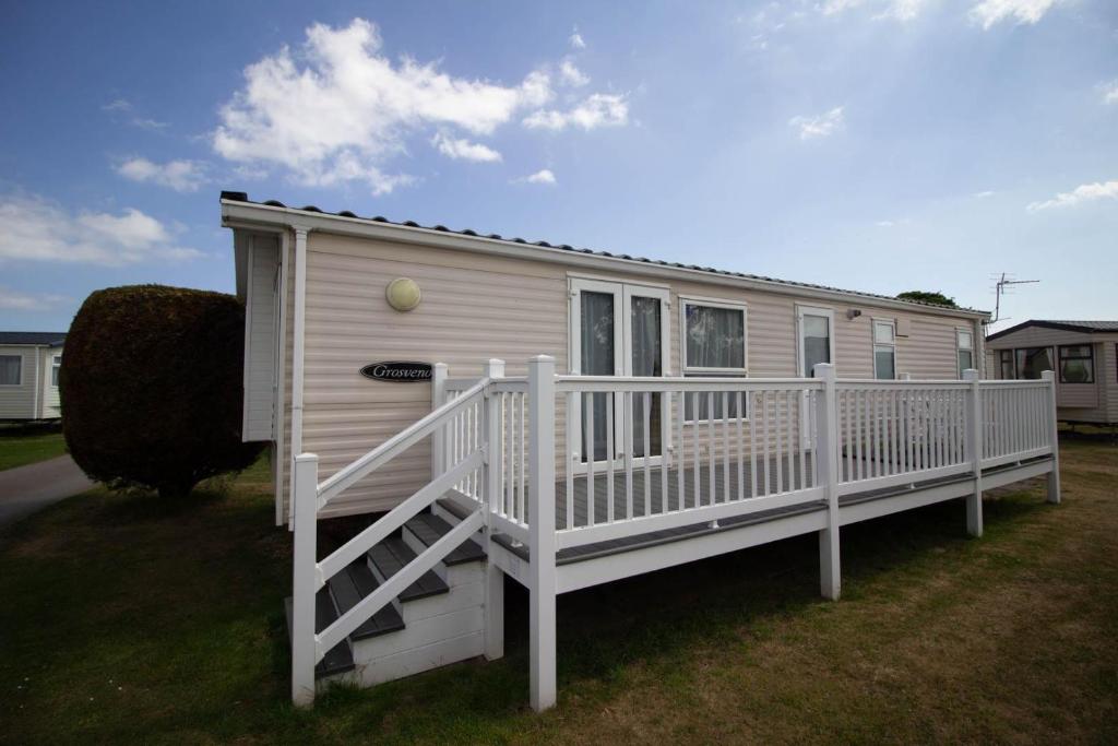 ラウスにあるLovely 6 Berth Caravan With Decking At Sunnydale Holiday Park Ref 35130sdの白い手すり付き白いモバイルホーム