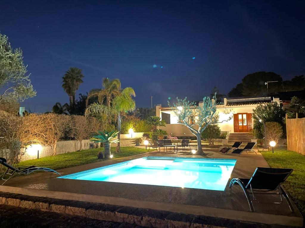 a swimming pool in a backyard at night at Villa Sara - Villa con piscina in Marina di Ragusa