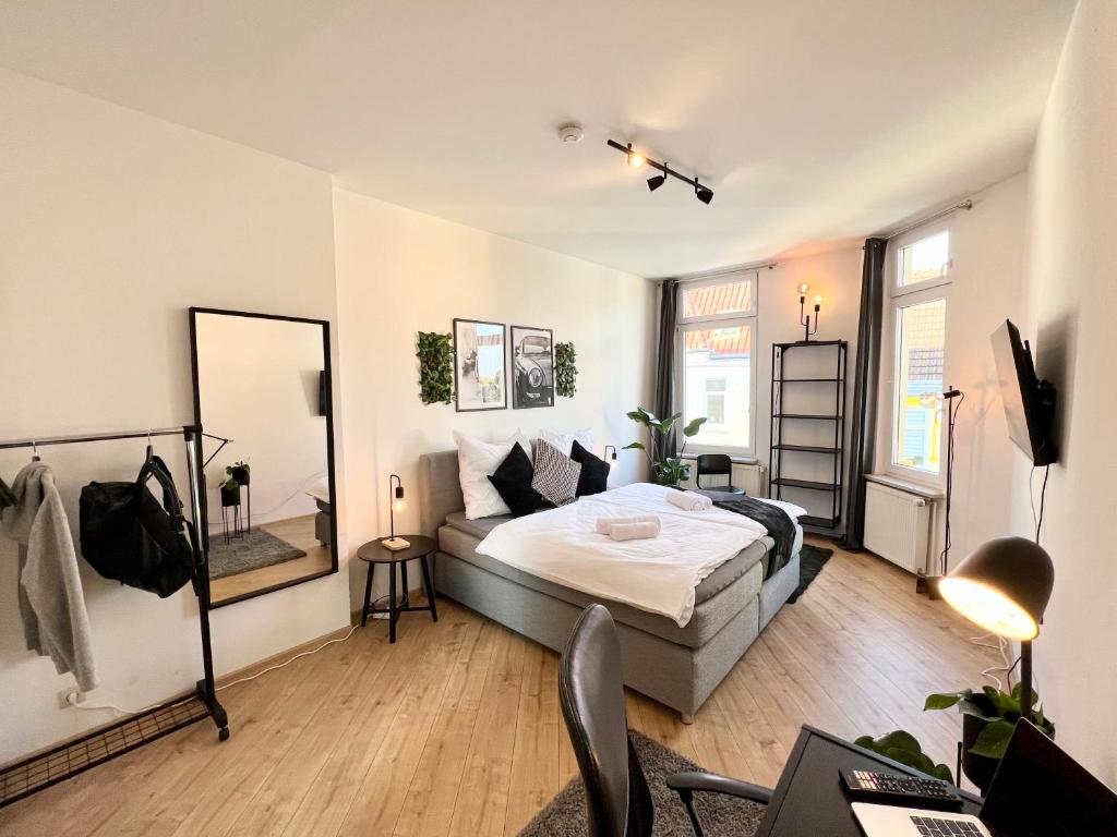 - une chambre avec un lit, un bureau et un miroir dans l'établissement Großes Apartment Bremerhaven, à Bremerhaven