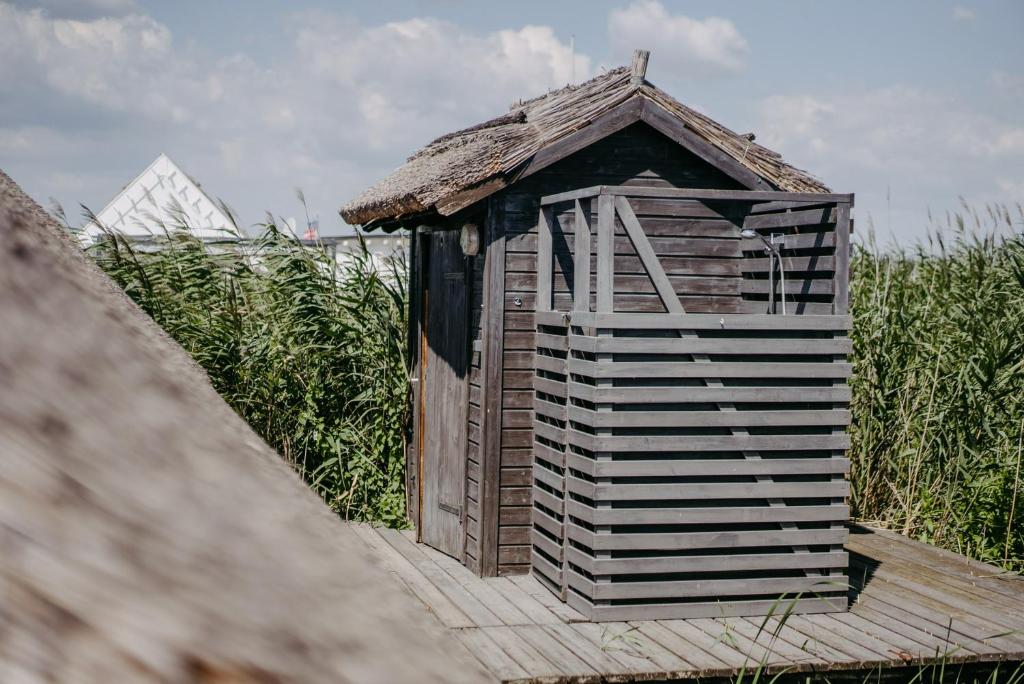 a wooden out house sitting in a field of grass at Seehütte Neusiedlersee inklusive Boot in Rust