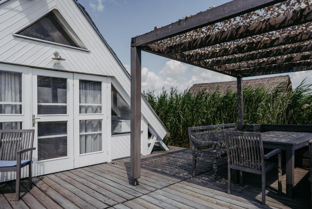 a patio with a table and chairs on a deck at Seehütte Neusiedlersee inklusive Boot in Rust