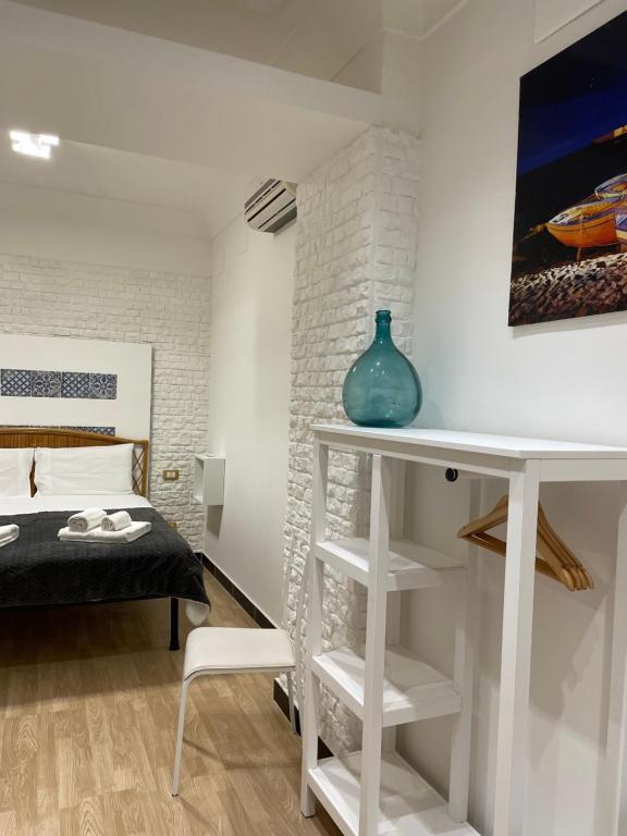 una camera da letto con un letto e un tavolo con un vaso sopra di Centro Città Basement a Palermo