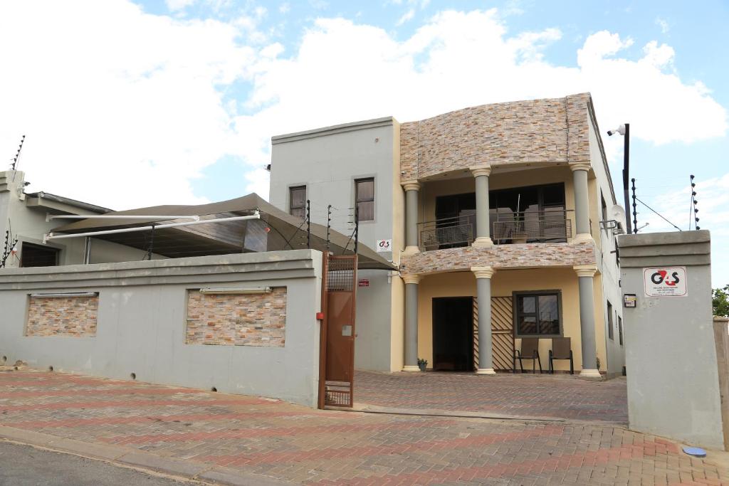 a building on a street with a brick sidewalk at Coco Palm Bed & Breakfast in Windhoek