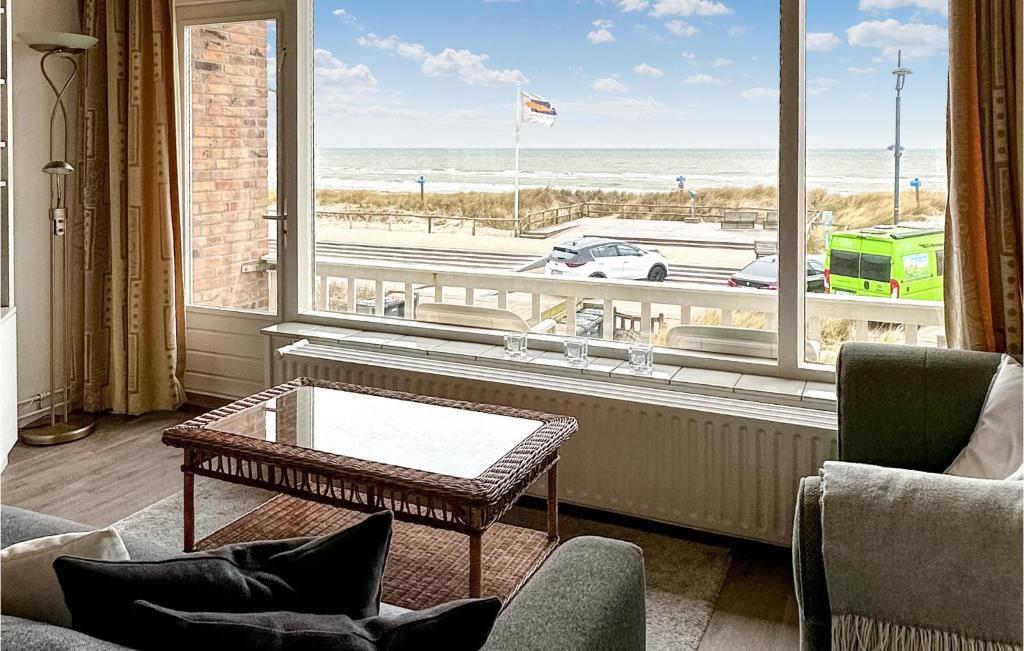 een woonkamer met een tafel en een groot raam bij Zwaluwnest in Bergen aan Zee