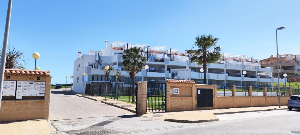 a large white building with palm trees in front of it at Casares Cozy Apartment in Casares