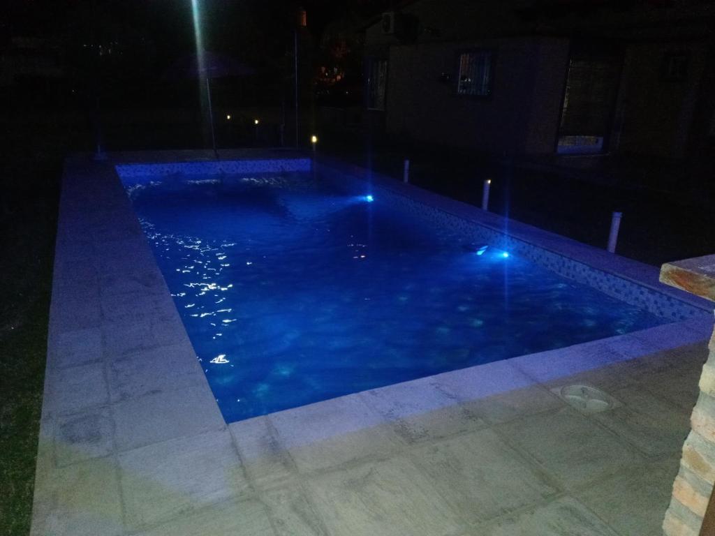 una piscina por la noche con luces azules en Casa cabaña juanita en Federación