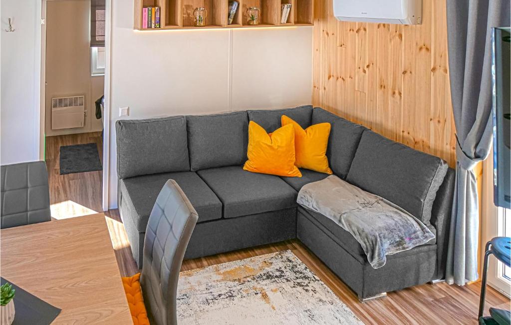 een woonkamer met een grijze bank met oranje kussens bij Blumenwiesenweg 15 in Untergriesbach