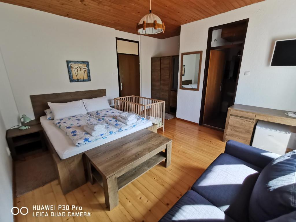 a living room with a bed and a couch at Tourist farm Anž'k in Bled