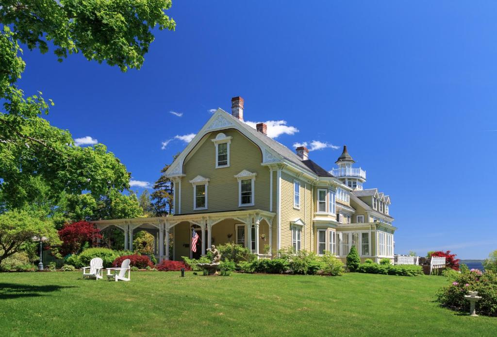 a large house on a grassy field at Captain Nickels Inn in Searsport