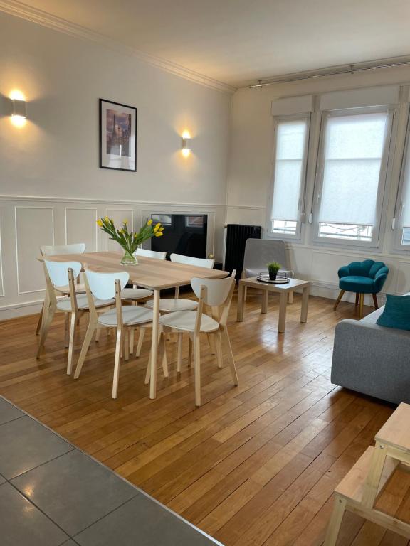 - un salon avec une table et des chaises en bois dans l'établissement Le cinquante-deux appartement de Charme, à Reims