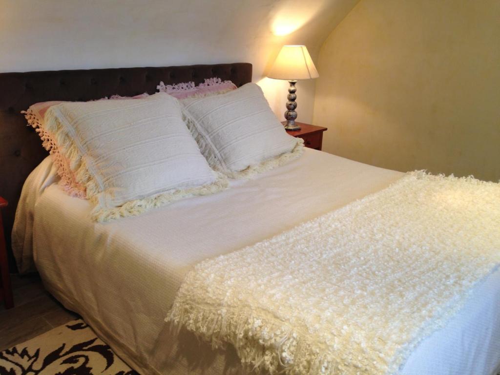 a bed with white sheets and pillows and a lamp at Chambres d&#39;hôtes Air Marin in Lannion