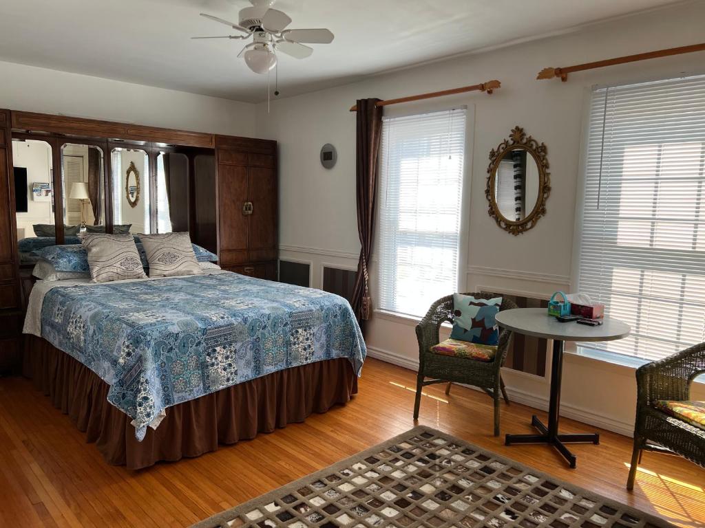 um quarto com uma cama, uma mesa e cadeiras em Cozy House B&B em Cataratas do Niágara