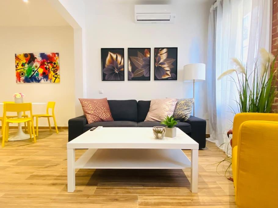 Style & Design Flat in the Center of Madrid في مدريد: غرفة معيشة مع أريكة وطاولة قهوة