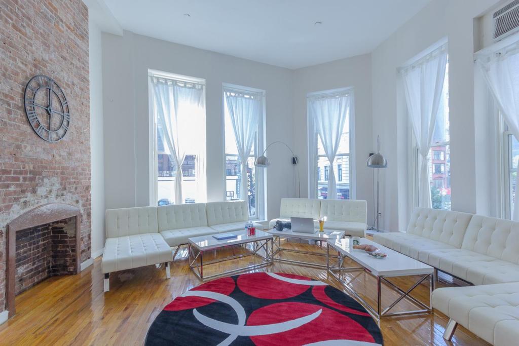 Studio Plus - Cozy Apartments في نيويورك: غرفة معيشة بأثاث أبيض وموقد