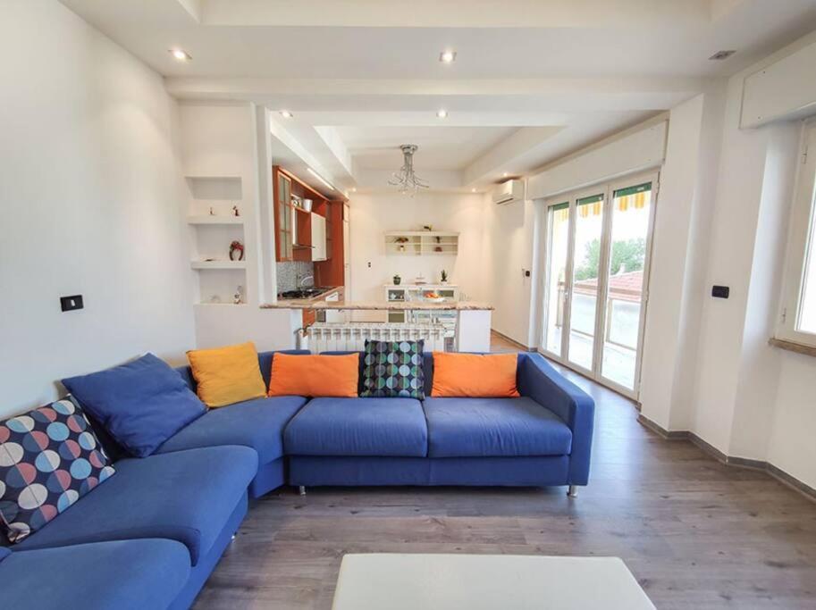 sala de estar con sofá azul y cocina en Ampio Quadrilocale 8 Pax vista mare en San Benedetto del Tronto