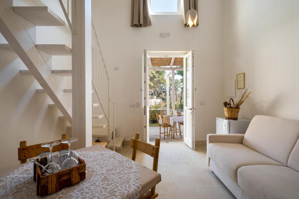 a living room with a white couch and stairs at Masseria Rauccio in Torre dell'Orso
