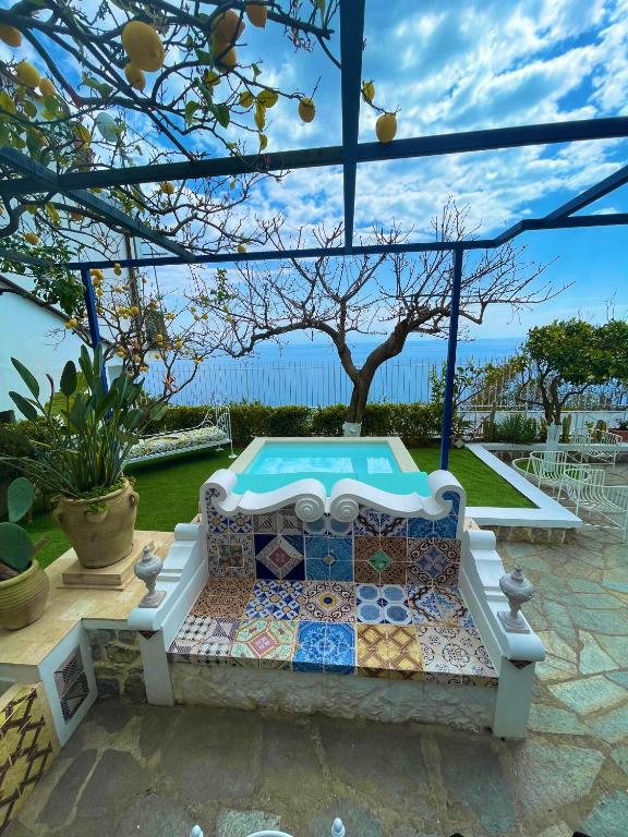a swimming pool in a backyard with a bench in a yard at Villa Marunnella in Praiano