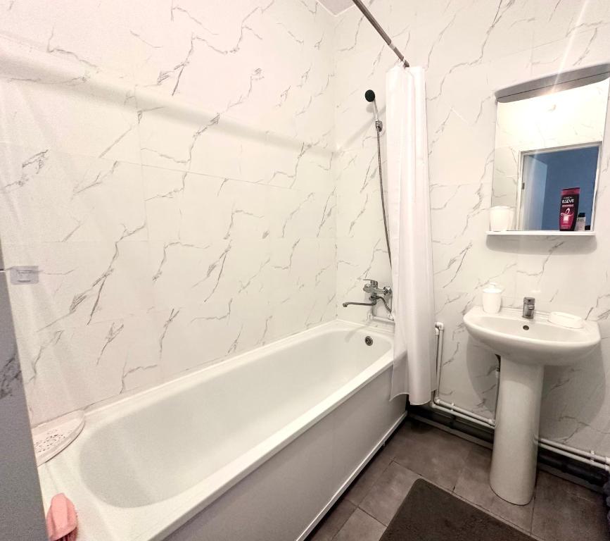 ein weißes Badezimmer mit Waschbecken, Badewanne und Toilette in der Unterkunft 1 комнатная драмтеатр 1bedroom apartment in Öskemen