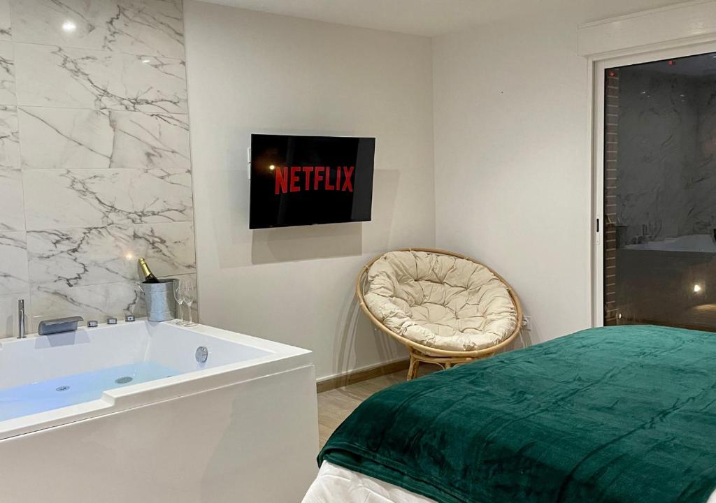 La salle de bains est pourvue d'un lit, d'un lavabo et d'une baignoire. dans l'établissement Lesmeralda Spa, à Évreux