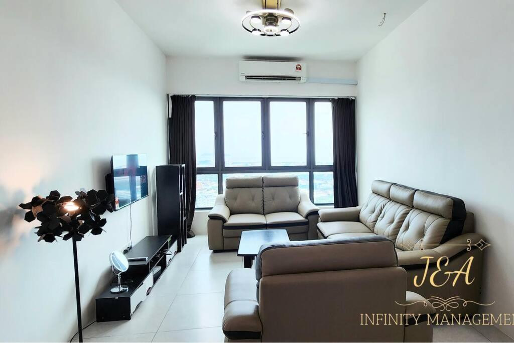 a living room with a couch and a tv at J&A Seaview Suites in Perai